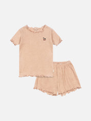 Beige pajama set with ruffled details on a light gray background