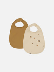 Two baby bibs, one mustard brown and one beige with a subtle lemon pattern.