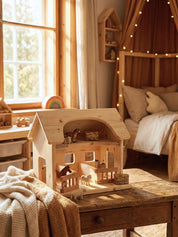 Wooden dollhouse with animals on a wooden table in a cozy room with a bed and window.